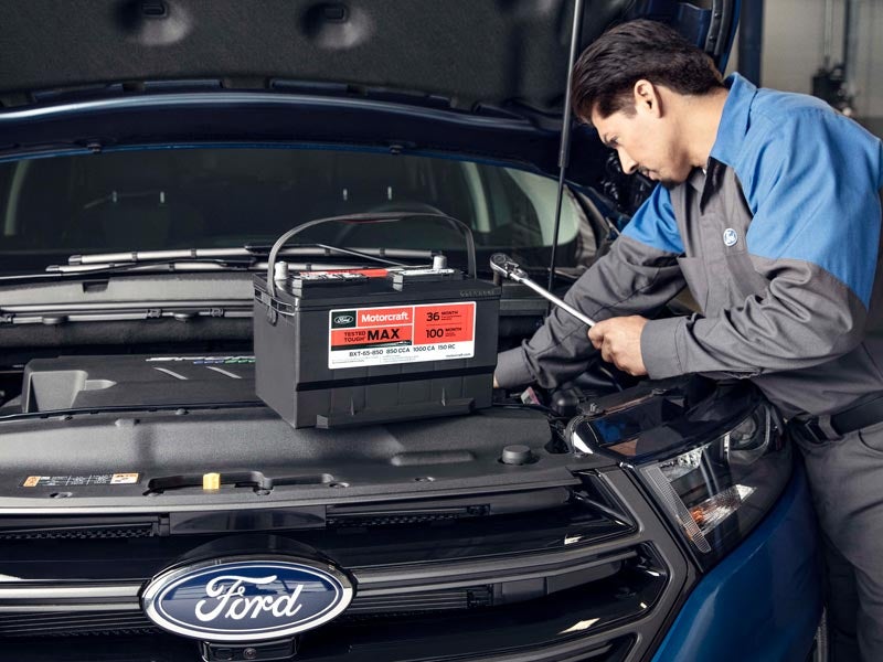 Technician installing a Motorcraft battery in a Ford vehicle